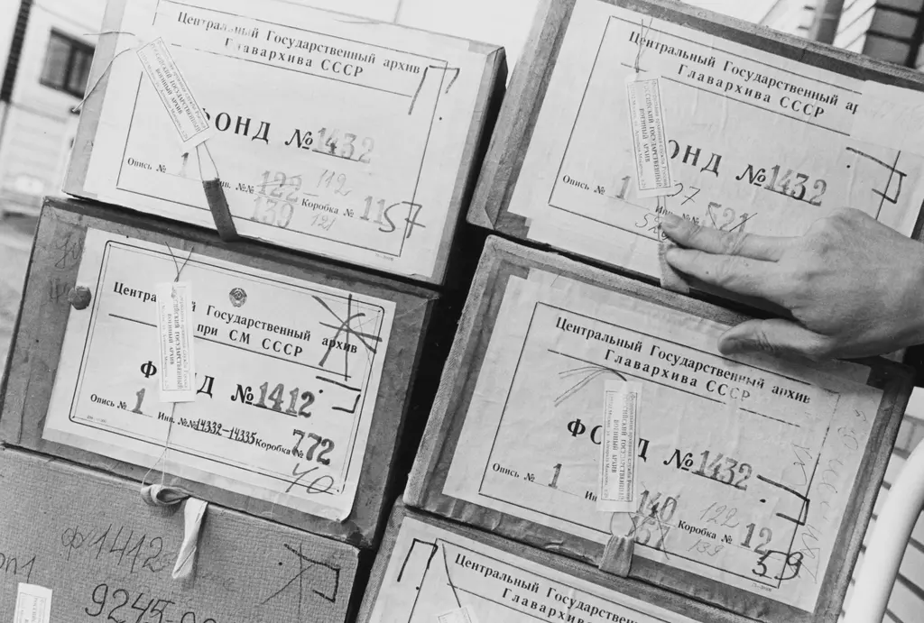 Archiefdozen met russische teksten erop en een wijzende hand