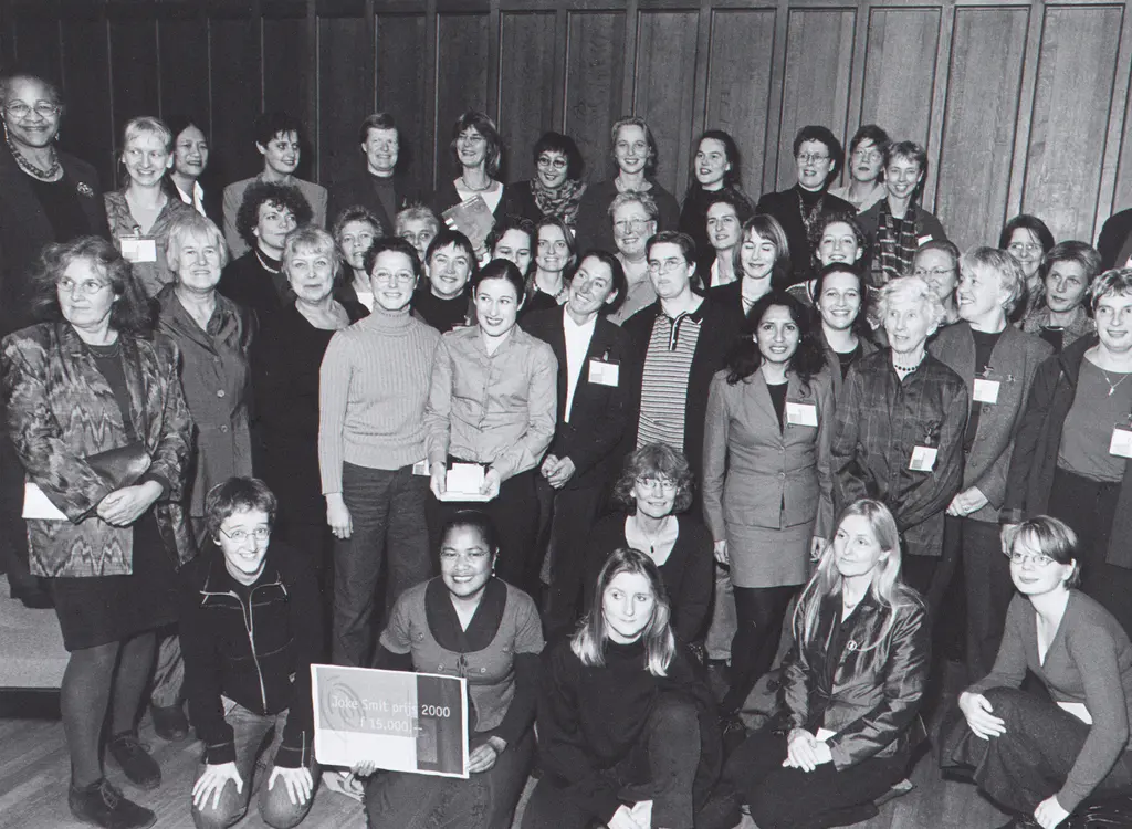 Groepsportret waarvan iemand op de voorgrond bord met Joke Smit prijs 2000 vasthoudt.