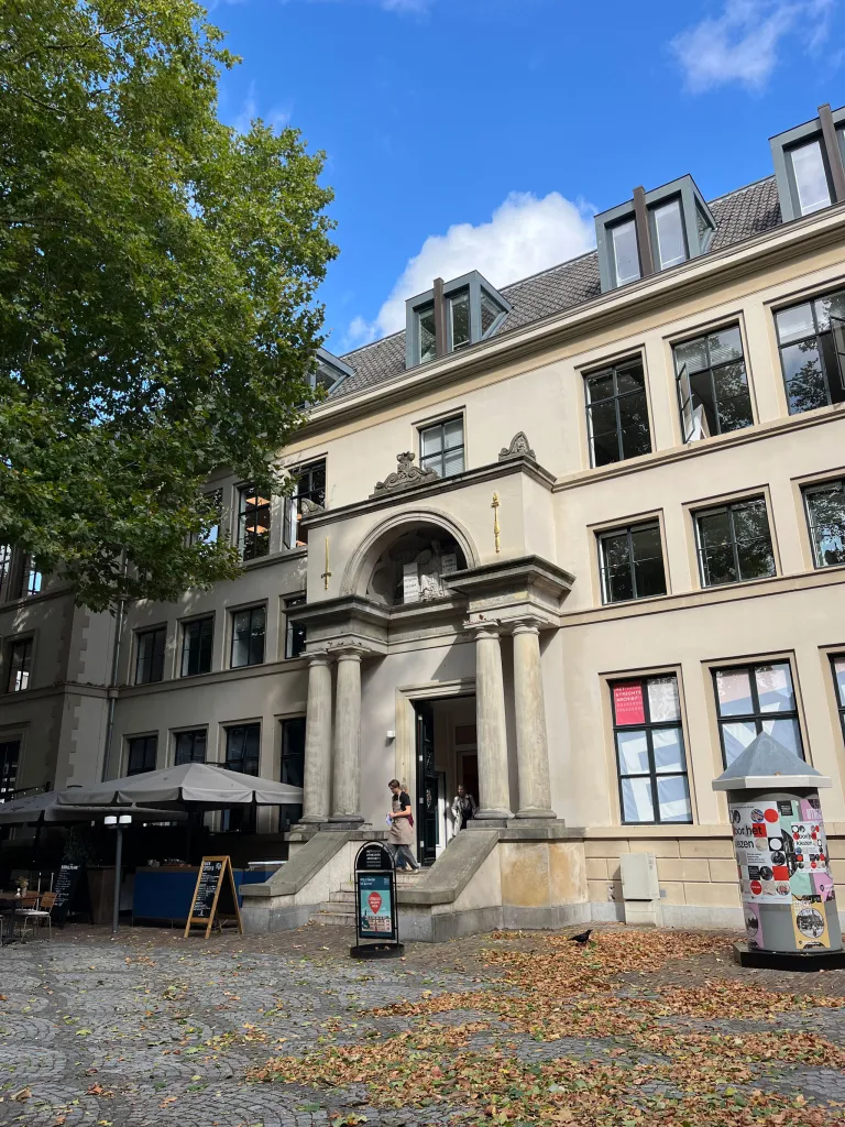 Pand van vier verdiepingen met ingang met pilaren in het het midden